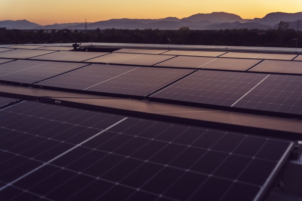 Industrial rooftop solar array at sunset